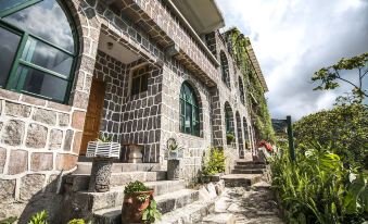 a brick house with green plants growing on the side of it , creating a natural and inviting atmosphere at Eco Hotel Uxlabil Atitlan