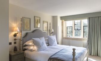 a cozy bedroom with a large bed and a window , providing a view of the outdoors at The Painswick