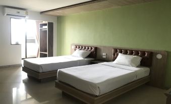 a hotel room with two beds , one on the left and one on the right side of the room at Lopburi Residence Hotel