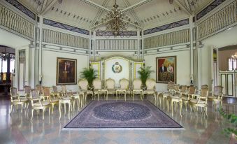 a large , ornate room with high ceilings and white walls , filled with chairs arranged in rows at Alila Solo