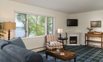 a cozy living room with a fireplace , couches , and a flat - screen tv mounted on the wall at Silver Birches Resort
