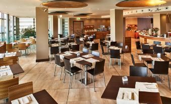 a modern restaurant with multiple dining tables and chairs , creating a pleasant atmosphere for guests at Hotel Cruise