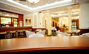 a well - decorated dining room with white chairs and tables , creating an inviting atmosphere for guests at Hotel Parus