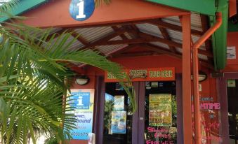 a small restaurant with a red awning and a green awning , located on a street at Dreamtime Travellers Rest