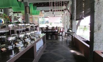 a restaurant with a large dining table , multiple chairs , and a variety of dishes on display at Felda Residence Hot Springs