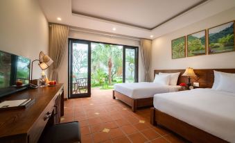 a hotel room with two twin beds and a large window overlooking a garden , providing a view of the outdoors at Bai Dinh Garden Resort & Spa