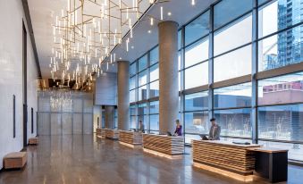 a modern hotel lobby with large windows , wooden reception desks , and a chandelier hanging from the ceiling at Hyatt Regency Seattle