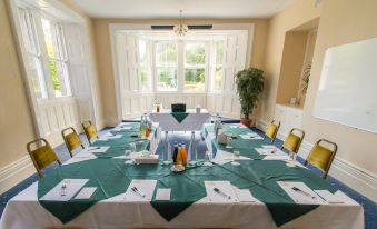 a conference room set up for a meeting , with tables and chairs arranged in a semicircle at Cumbria Grand Hotel