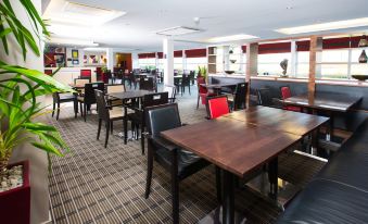 a large dining room with multiple tables and chairs arranged for a group of people to enjoy a meal together at Holiday Inn Express Milton Keynes