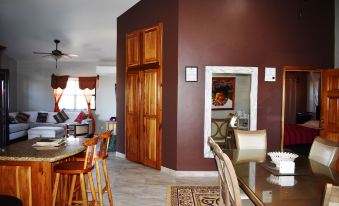 a dining room with a wooden table and chairs , along with a kitchen area with appliances at Lucina's