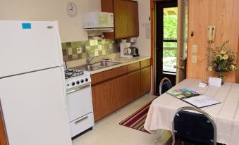 a small kitchen with a dining table and chairs , as well as a refrigerator and microwave at Betsie Riverside Resort