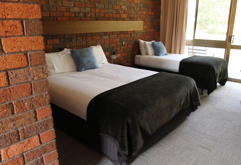 a room with two beds , one on the left side and the other on the right side of the room at Bonnie Doon Hotel
