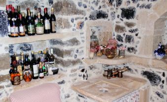 a stone wall with a wine rack and bottles of alcohol lining the shelves , creating a cozy atmosphere at Villa Rosa
