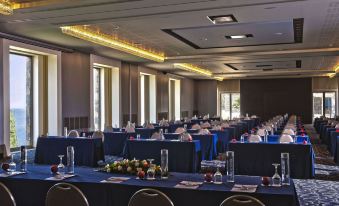 a large conference room with rows of chairs and tables set up for a meeting or event at Daios Cove