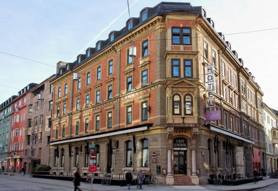 a brick building with a large sign on the front , located in a city setting at Hotel Central