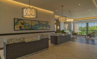 a modern hotel lobby with marble floors , large windows , and chandeliers hanging from the ceiling at Sheraton Austin Georgetown Hotel & Conference Center