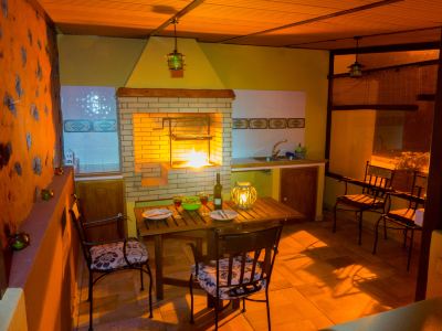 a cozy kitchen with wooden furniture , including a dining table and chairs , and a fireplace at Titi Titi Photo