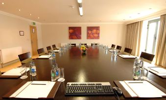 a conference room with a large table and multiple chairs , surrounded by water bottles and a computer keyboard at The Parkview Hotel