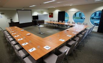 a conference room with a large wooden table , chairs , and water bottles set up for a meeting at Quest Mildura