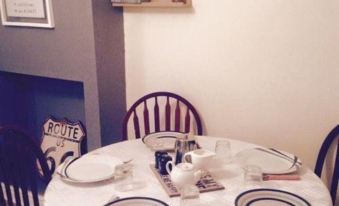 a dining table with white plates , cups , and saucers is set up in a room at Number 19 Guest House - 4 Miles from Barrow in Furness - 1 Mile from Safari Zoo