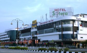 a large hotel building situated on the side of a busy street , surrounded by cars and traffic at Hotel Sfera