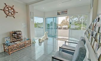 a modern living room with a white dog figurine on the floor and a large window providing natural light at Robetown Motor Inn & Apartments