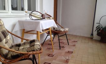 a small dining area with a table and two chairs , as well as a television in the background at Bike Apartment