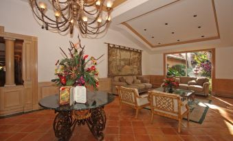 a well - decorated living room with a wooden floor , a chandelier hanging from the ceiling , and a couch in the background at Grand Palms Spa & Golf Resort