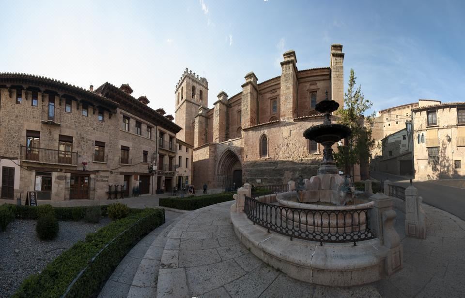 a large stone building with a fountain in front of it , surrounded by a courtyard at Hotel Mora
