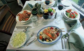 a dining table set with a variety of food items , including a lobster , vegetables , and wine at Dexter's Inn