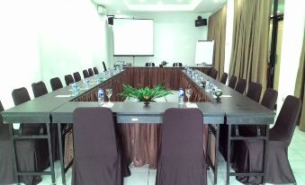 a large conference room set up for a meeting , with chairs arranged in a semicircle around a long table at Hotel Bandara Syariah