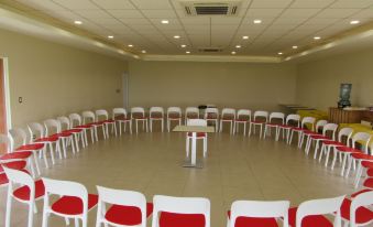 a large room with rows of red and white chairs arranged in a circular pattern at Atami Escape Resort