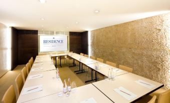 a conference room set up for a meeting , with tables and chairs arranged in a semicircle at Residence Hotel