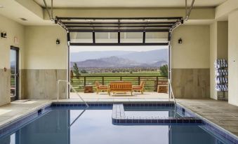 a small outdoor pool surrounded by a patio , with a view of the mountains in the distance at Red Sands Hotel