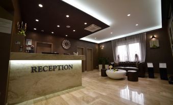 "a modern reception area with a large clock , a desk , and a sign reading "" reception "" on the wall" at Royal Airport Hotel
