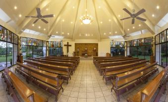 a large , empty church with wooden pews and a cross on the ceiling , under high ceilings at Canyon Woods Resort Club