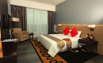 a hotel room with a king - sized bed , a flat - screen tv , and various other furnishings at Raia Hotel & Convention Centre Alor Setar