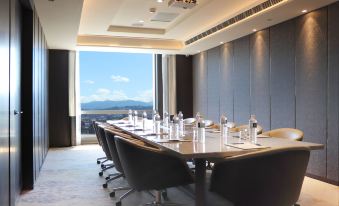 a large conference room with a long table , multiple chairs , and a view of the ocean at Caesar Park Hotel Banqiao