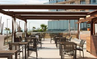 an outdoor dining area with tables and chairs set up for guests to enjoy a meal at Hotel Flamingo