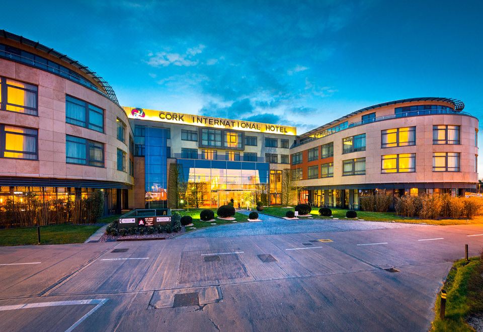 a large hotel building with multiple floors , surrounded by trees and located at the intersection of two streets at Cork International Hotel