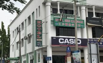 a city street with a white building on the left side and a storefront on the right side at Hotel Seri Kangsar KK Hotel