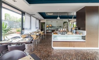 a modern restaurant with a bar area , where people are enjoying their meals and drinks at Idea Hotel Milano Malpensa Airport