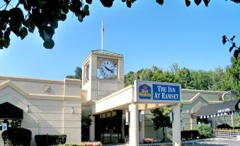 "a large hotel with a clock on the front entrance and a sign that reads "" the inn at ramsey .""." at Best Western the Inn at Ramsey