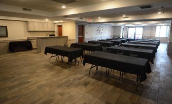 a large , empty conference room with multiple rows of tables and chairs set up for meetings or events at Archer House