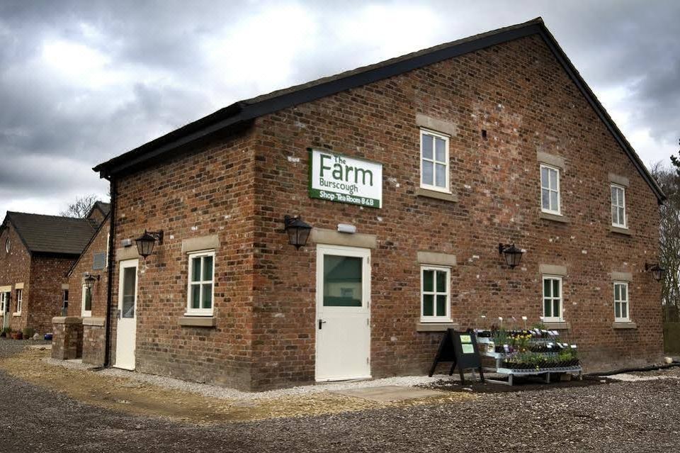 "a brick building with a sign that reads "" farm "" on it , located in a rural area" at The Farm Burscough