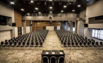 a large conference room with rows of chairs arranged in a semicircle , ready for an event at Rila Hotel Borovets