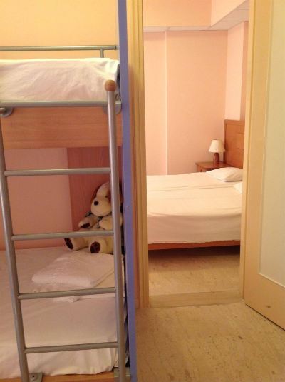 a small room with three bunk beds and two single beds , one of which has a teddy bear on it at Hotel Summery