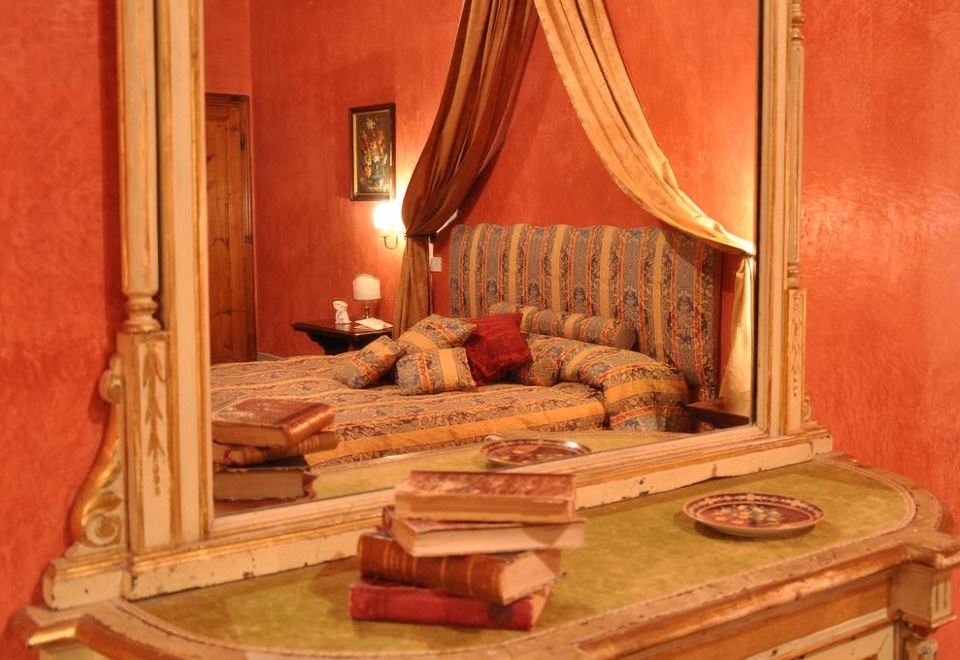 a large mirror reflects a bed with pillows and blankets , creating an inviting atmosphere in a room at Villa Il Leccio