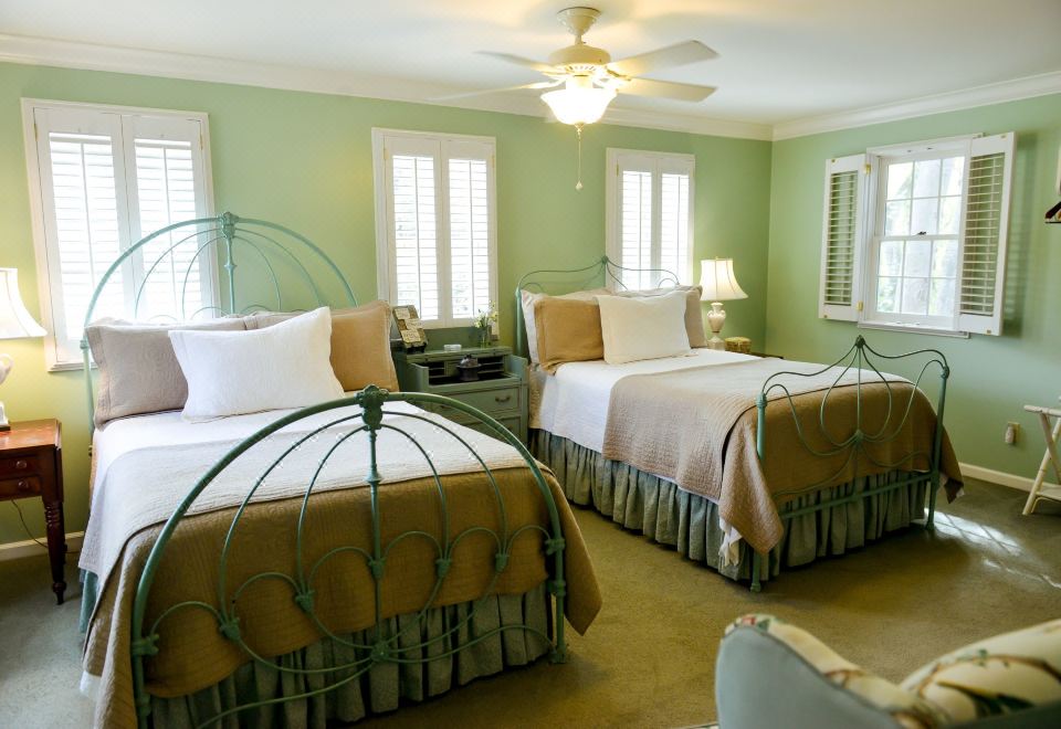 a hotel room with two twin beds , one on the left side of the room and the other on the right side at Green Tree Inn