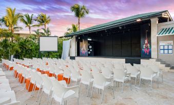 an outdoor event space with rows of white chairs and a stage set up for an event at Emotions by Hodelpa - Juan Dolio